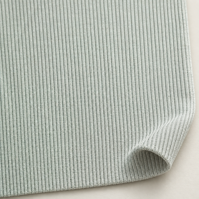 Styled photograph of natural-color 2x1 rib knit fabric; original fabric photograph follows.